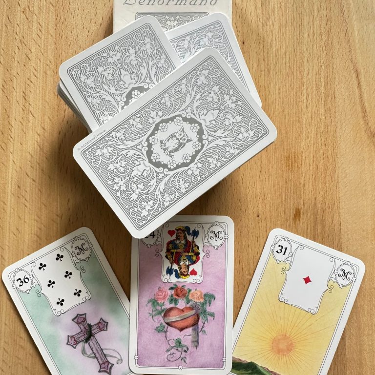 Kartenlegen Ein Stapel Karten mit verschiedenen Motiven, darunter ein Kreuz und ein Herz.